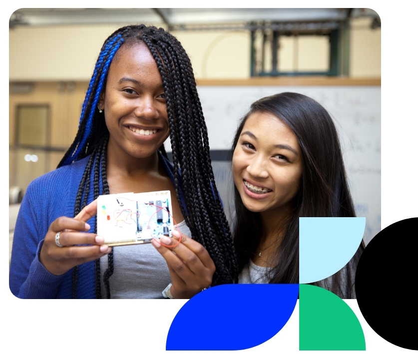 Two students smiling in front of a whiteboard